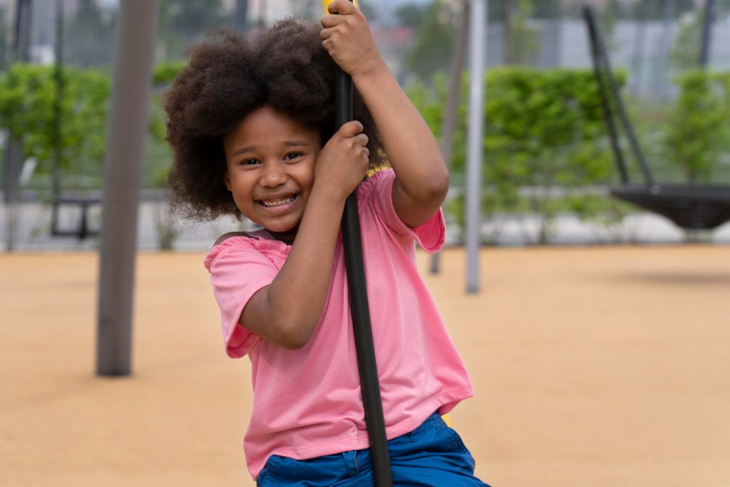 Image by <a href="https://www.freepik.com/free-photo/medium-shot-smiley-kid-outdoors_17808670.htm#query=playground%20kids%20ethnic&position=41&from_view=search&track=ais">Freepik</a>